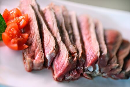 Entrecote grilled sliced with tomatoes in white plateの写真素材