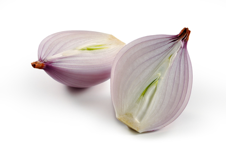Red onion cut in half on white boardの写真素材