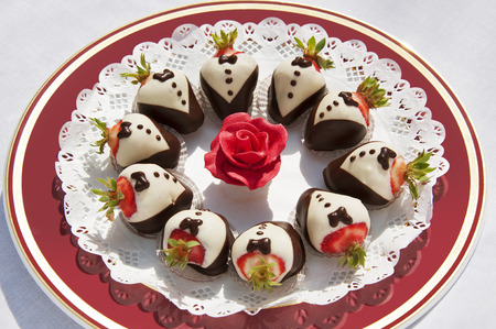 Dessert plate with strawberries dressed in chocolate tailsの写真素材