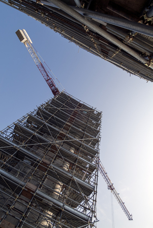 Construction site facility under construction with scaffolding and cranes