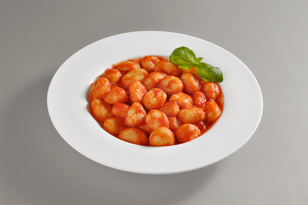 Plate with portion of tomato dumplings isolated on grey backgroundの写真素材