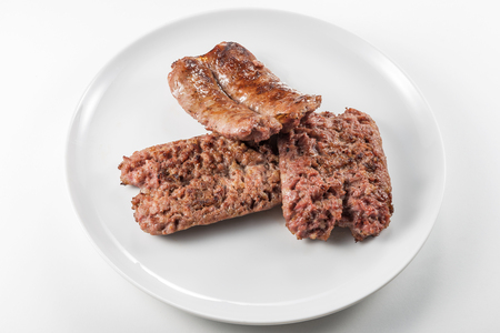 Round white dish with grilled sausages isolated on white backgroundの写真素材