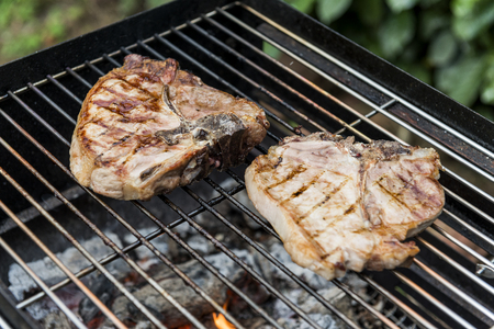 T-bone chop of pork on the grill of barbecueの写真素材