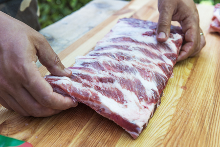 Butcher preparing rack of pork ribs for cookingの写真素材