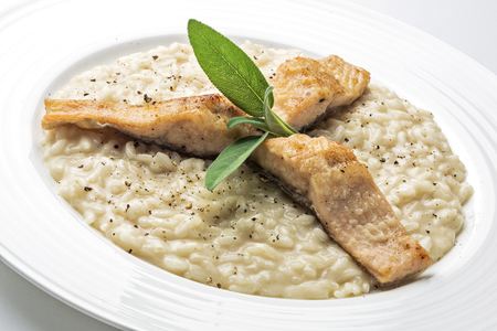 Parmesan risotto dish with trout fillet isolated on white backgroundの写真素材