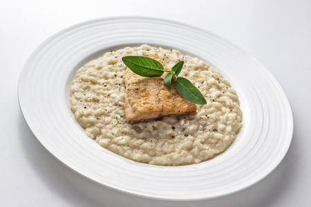 Parmesan risotto dish with trout fillet isolated on white backgroundの写真素材