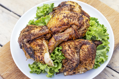 Round white Dish with pieces of grilled chicken with saladの写真素材
