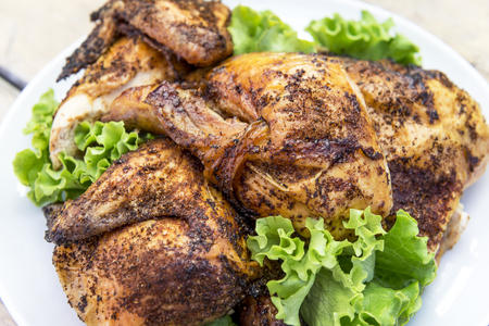 Round white Dish with pieces of grilled chicken with saladの写真素材