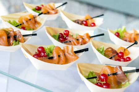 Detail of buffet Tray with mini portions of sliced salmon and black currant