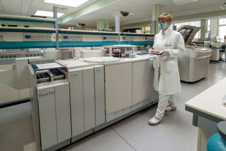 Milan, Italy - March 17, 2020: Operator with rack of blood tubes in laboratory for analysis in...
