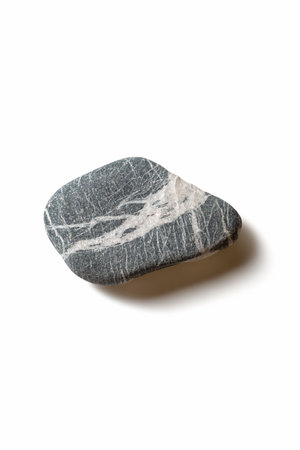 Single pebble with shadow on white backgroundの写真素材