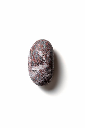 Single pebble with shadow on white background
