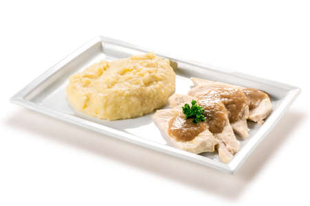 Rectangular plate with slices of white meat and mashed potatoes isolated on white backgroundの写真素材