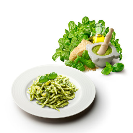 Plate of trofie with Genoese pesto sauce with mortar and ingredients vertical cut on a white backgroundの写真素材