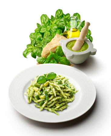 Plate of trofie with Genoese pesto sauce with mortar and ingredients vertical cut on a white backgroundの写真素材