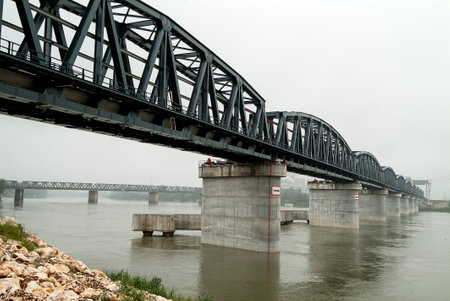 Perspective view of Iron bridge on concrete piers over the riverの写真素材