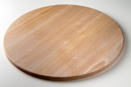 Smooth and empty round wooden chopping board isolated on white backgroundの写真素材
