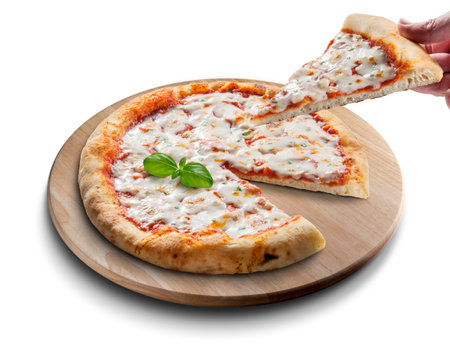 Classic round margherita pizza sliced on wooden cutting board and hand with sliceの写真素材