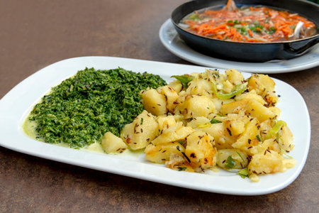 Rectangular dish with chopped spinach and potatoes and spring onion on rough backgroundの写真素材