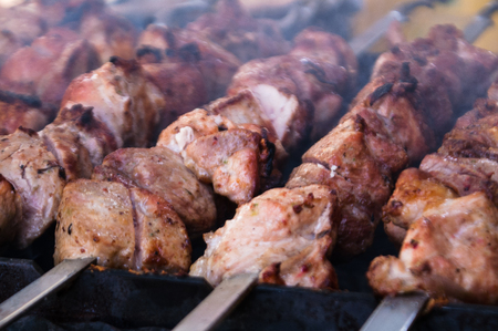 Shish kebab on a skewer fried on open coals of a fireの写真素材