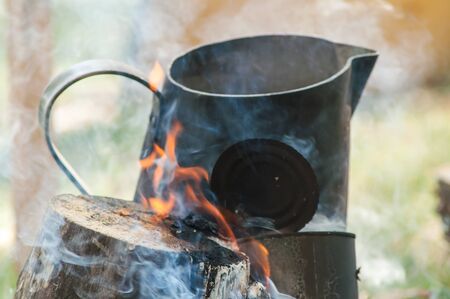 Metallic black circle on the fire to make tea and coffee in the campaign
