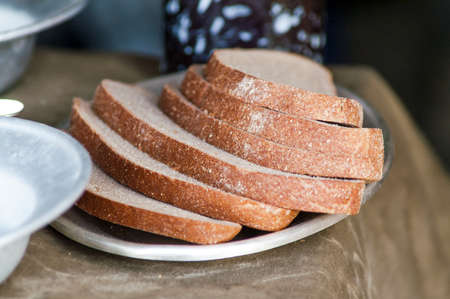lying sliced brown bread on a metal plate