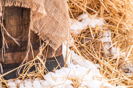 wooden barrel near the straw on the snow