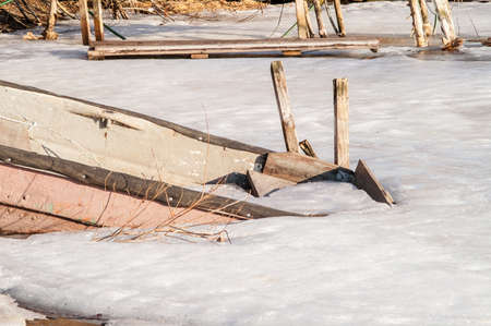 icebound old boat in the river during the dayの写真素材