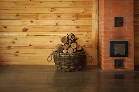 round oak firewood stacked in the basket near the stoveの写真素材