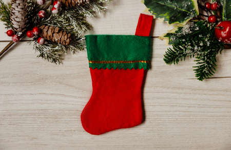 Festive Christmas and new year card with red and green sock on gray wooden background