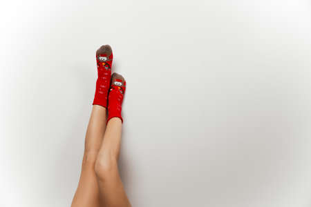 Woman leg in red christmas socks on gray isolated background
