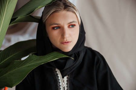 Beautiful muslim woman in traditional arabian abaya dress on gray backgroundの写真素材