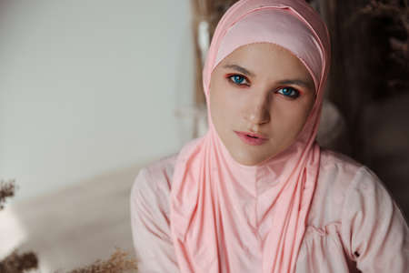 Portrait of beautiful muslim arabian woman wearing pink hijab look at cameraの写真素材