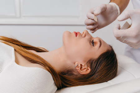Doctor examining patient nose after rhinoplasty surgery, medical operationの写真素材