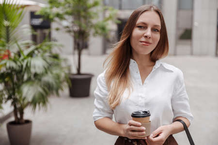 Close-up Young business woman holding coffee of the modern city streetの写真素材