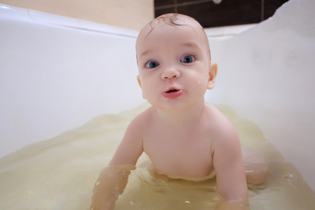 Cute boy enjoying bath, playing with water.の写真素材