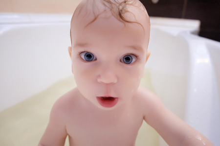 Cute boy enjoying bath, playing with water.