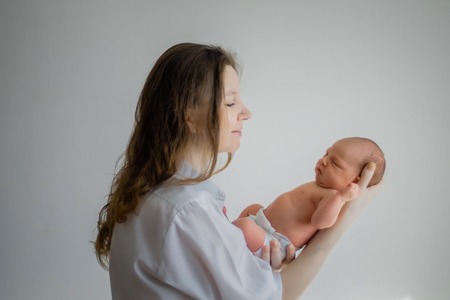 Pretty woman holding a newborn baby in her armsの写真素材