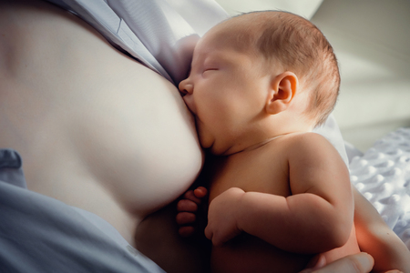 mother feeding her newborn with breastの写真素材