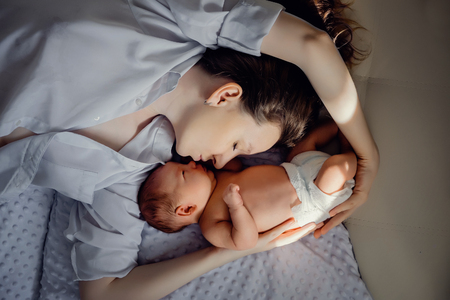 A young mother and a newborn boy are lying nearby. Mothers Dayの写真素材