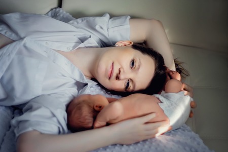 A young mother and a newborn boy are lying nearby. Mothers Dayの写真素材