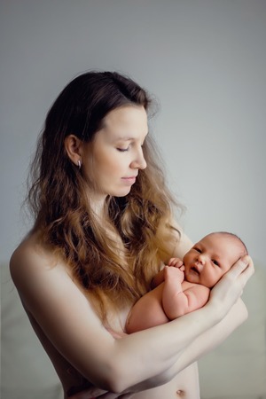Young mother with a baby in her arms. Without clothing. life styleの写真素材