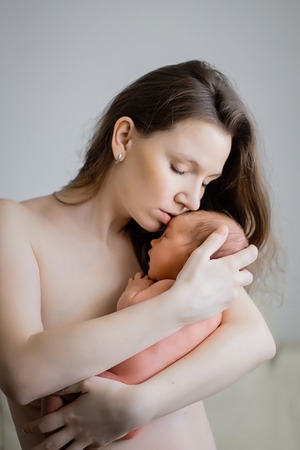Young mother with a baby in her arms. Without clothing. life styleの写真素材