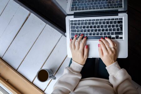 The girl works at the laptop book and drinks black coffee.の写真素材