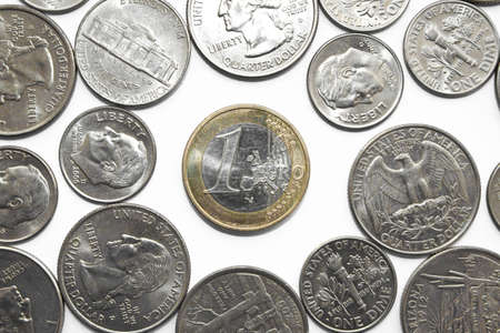 One Euro coin among dollar coins.
