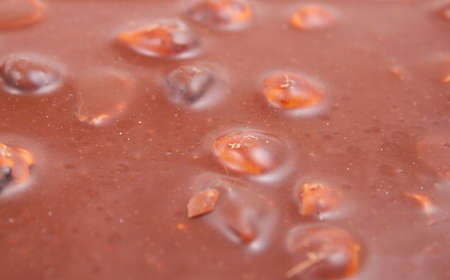 Colorful chocolate surface with whole nuts and raisins.の写真素材