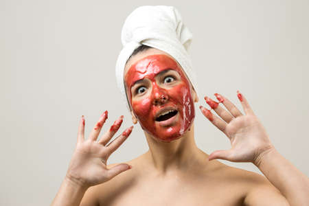 Beauty portrait of woman in white towel on head with gold nourishing mask on face. Skincare...