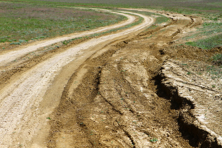Unpaved dry dirt country road in spring steppe, offroad driveの写真素材