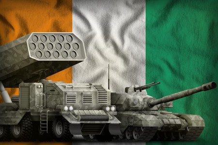 tank and rocket artillery with city camouflage on the Cote d Ivoire flag background. Cote d Ivoire heavy military armored vehicles concept. 3d Illustrationの写真素材