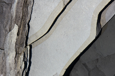 Light and dark grey stone surface texture with cracks.